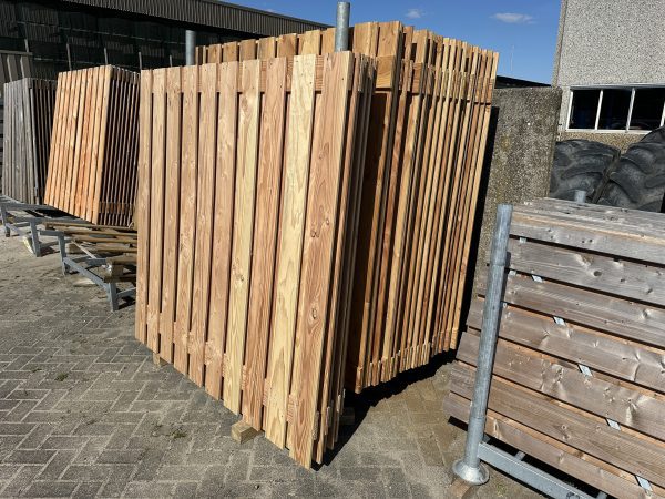 Schuttingdelen van Douglas in een bok op parkeerplaats van Bouwie