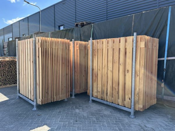 Schuttingdelen van Douglas in een bok op parkeerplaats van Bouwie