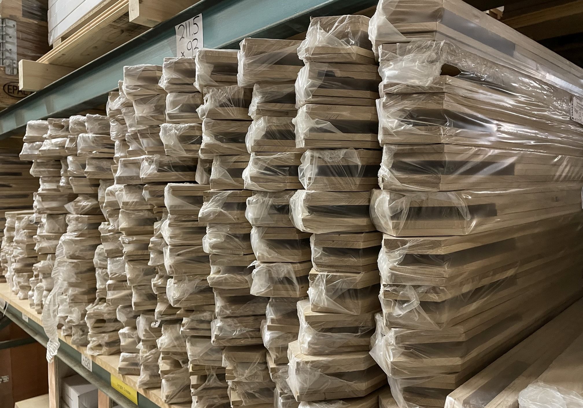 Roedepakketten magazijn (Aangepast) Roedepakketten in stapels opgeslagen in het magazijn van Bouwie. Deze roedepakketten zijn ten behoeve van de eiken deuren van Bouwie